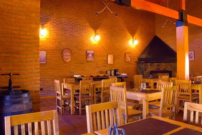 a restaurant with wooden tables and chairs and a brick wall at Lauquen Pilmaiquen y spa in Merlo