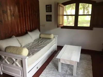 a bed in a room with a table and a window at La casita en la Juni in San Javier