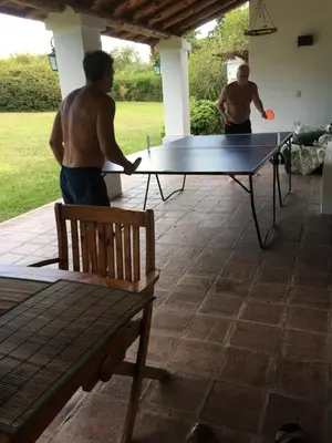 two men playing ping pong on a ping pong table at La casita en la Juni in San Javier