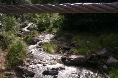 a bridge over a river with rocks and trees at La casita en la Juni in San Javier