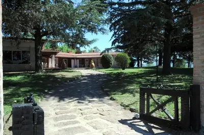 a house with a gate in front of a yard at Hotel Parque Siquiman in Villa Carlos Paz