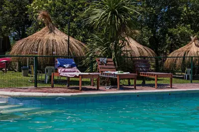 two chairs sitting next to a swimming pool at Hotel Parque Siquiman in Villa Carlos Paz