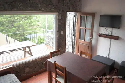 a dining room with a table and a balcony at Cabañas Alma de Pueblo, Mayu Sumaj in San Antonio de Arredondo