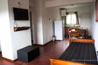 a living room with a white refrigerator and a table at Cabañas Alma de Pueblo, Mayu Sumaj in San Antonio de Arredondo