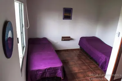 two beds in a small room with purple sheets at Cabañas Alma de Pueblo, Mayu Sumaj in San Antonio de Arredondo