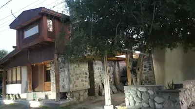 a small house with a stone wall at Altos del Molle SF in San Francisco del Monte de Oro