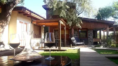 two glasses of wine on a table in front of a house at Altos del Molle SF in San Francisco del Monte de Oro