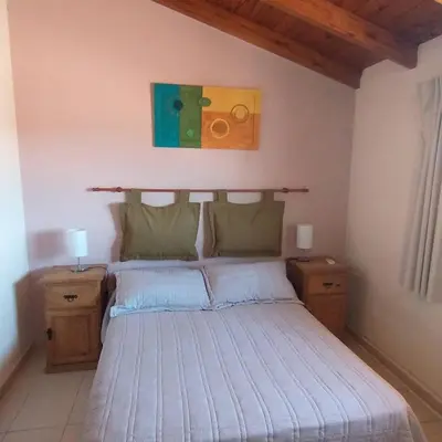 a bedroom with a bed with two night stands and two lamps at Duplex a mts del Rio con Aire Acond in Villa Carlos Paz