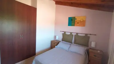 a bedroom with a bed and a painting on the wall at Duplex a mts del Rio con Aire Acond in Villa Carlos Paz