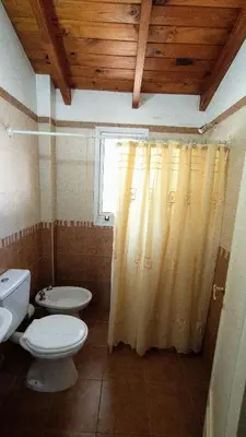 a bathroom with a toilet and a shower curtain at Duplex a mts del Rio con Aire Acond in Villa Carlos Paz