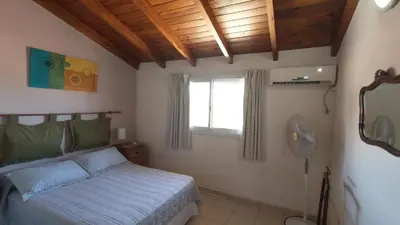 a bedroom with a bed and a window and a fan at Duplex a mts del Rio con Aire Acond in Villa Carlos Paz