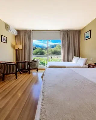 a hotel room with two beds and a large window at Howard Johnson Hotel & Spa Villa General Belgrano in Villa General Belgrano