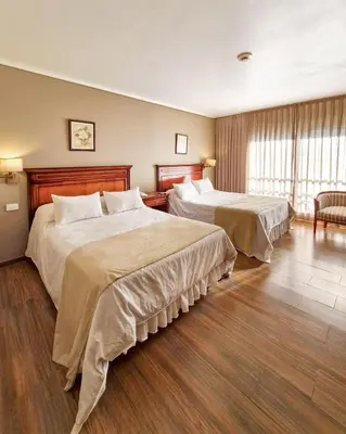 a hotel room with two beds in a room at Howard Johnson Hotel & Spa Villa General Belgrano in Villa General Belgrano
