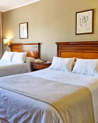 a hotel room with two beds with white pillows at Howard Johnson Hotel & Spa Villa General Belgrano in Villa General Belgrano