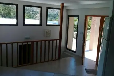 a living room with four windows and a staircase at Casa en La Cumbrecita in La Cumbrecita