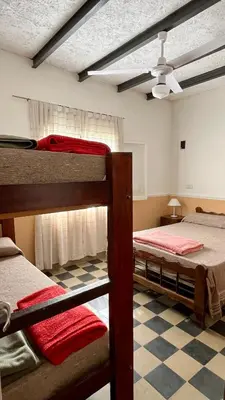 a bedroom with two bunk beds and a ceiling fan at Casa en el centro in Villa Cura Brochero