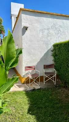 two chairs are sitting next to a building at Casa en el centro in Villa Cura Brochero