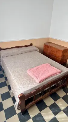 a bedroom with a bed and a wooden dresser at Casa en el centro in Villa Cura Brochero