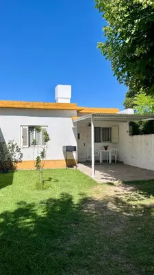 a white house with a lawn in front of it at Casa en el centro in Villa Cura Brochero