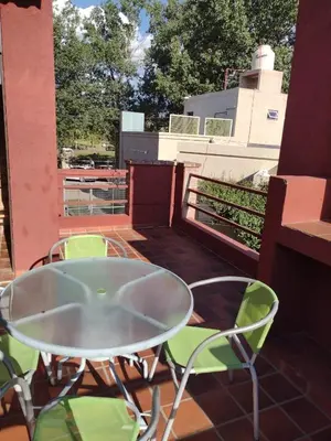 a glass table and chairs on a balcony at Las Cuatro Estaciones in Villa Cura Brochero