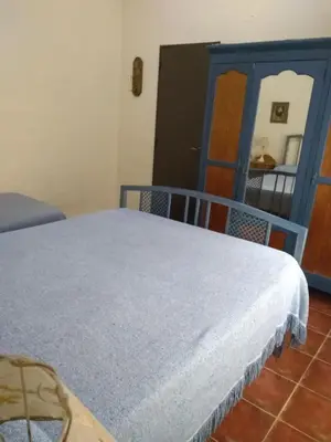 a bedroom with a bed and a blue cabinet at Las Cuatro Estaciones in Villa Cura Brochero