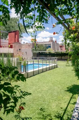 a swimming pool in a yard with green grass at Las Cuatro Estaciones in Villa Cura Brochero