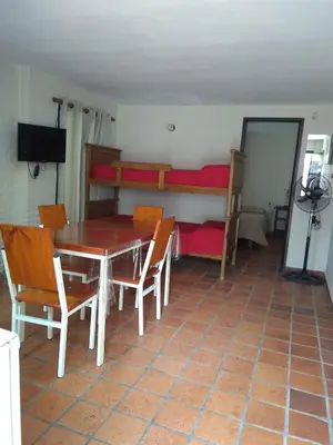 a dining room with a table and chairs and a bunk bed at Las Cuatro Estaciones in Villa Cura Brochero