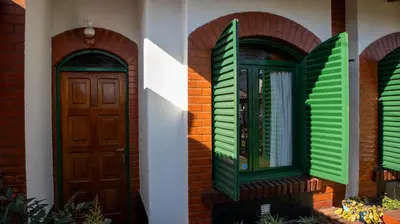 two green doors on a brick house at Bungalows Punta Azul in Villa Carlos Paz