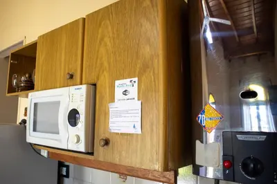 a microwave on top of a kitchen refrigerator at Bungalows Punta Azul in Villa Carlos Paz