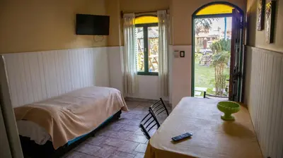 a bedroom with a bed and a table and a window at Bungalows Punta Azul in Villa Carlos Paz