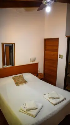a bedroom with a bed with two towels on it at Bungalows Punta Azul in Villa Carlos Paz
