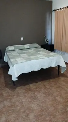 a bedroom with a bed with a blanket on it at Los Ceibos in Villa Carlos Paz