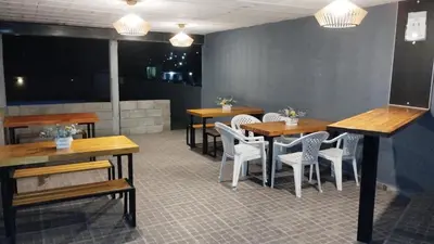 a restaurant with wooden tables and white chairs at Los Ceibos in Villa Carlos Paz
