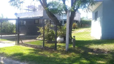a fence around a tree in front of a house at Los Ceibos in Villa Carlos Paz