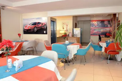 a restaurant with tables and chairs and a car on the wall at Hotel Capvio in Villa Carlos Paz