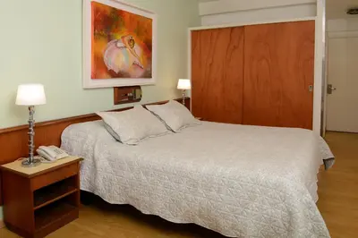 a bedroom with a bed and a phone on a table at Hotel Capvio in Villa Carlos Paz