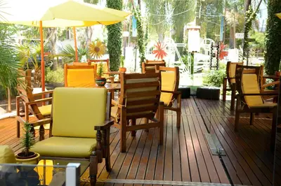 a group of chairs and an umbrella on a deck at Hotel Capvio in Villa Carlos Paz