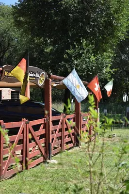 a fence with flags on it in a field at Montañas Del Sol in Santa Rosa de Calamuchita
