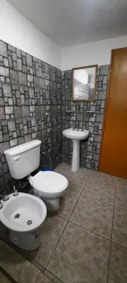 a bathroom with a toilet and a sink at Montañas Del Sol in Santa Rosa de Calamuchita