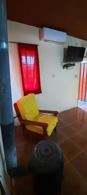 a room with a yellow chair and a window at Montañas Del Sol in Santa Rosa de Calamuchita