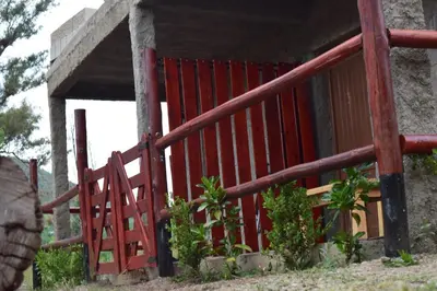 a red fence in front of a building at Montañas Del Sol in Santa Rosa de Calamuchita
