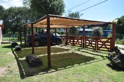 a wooden pavilion with a car parked under it at Montañas Del Sol in Santa Rosa de Calamuchita