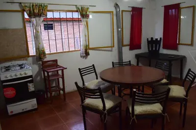 a kitchen with a table and chairs and a stove at Montañas Del Sol in Santa Rosa de Calamuchita