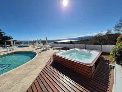 a hot tub sitting on a deck next to a swimming pool at Le Mirage Village Club Resort in Villa Carlos Paz