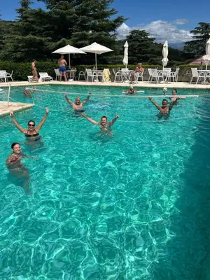 a group of people swimming in a swimming pool at Le Mirage Village Club Resort in Villa Carlos Paz
