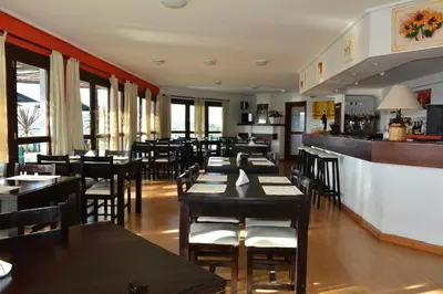 a restaurant with tables and chairs and a bar at Le Mirage Village Club Resort in Villa Carlos Paz