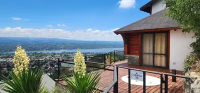 a house with a balcony with a view of a lake at Le Mirage Village Club Resort in Villa Carlos Paz