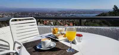 a table with a glass of orange juice on a balcony at Le Mirage Village Club Resort in Villa Carlos Paz