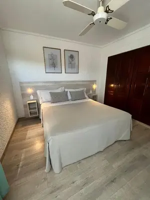 a bedroom with a white bed and a ceiling fan at Le Mirage Village Club Resort in Villa Carlos Paz