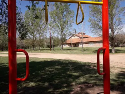 a playground with a red swing in a park at Atahualpa mi Posada in Mina Clavero
